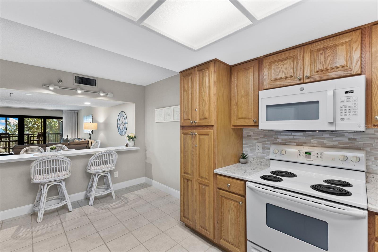 Kitchen has wood-faced cabinetry and a breakfast bar