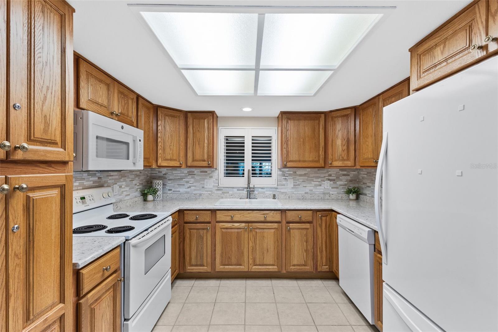 Kitchen with newer appliances, quartz countertops, tile backsplash