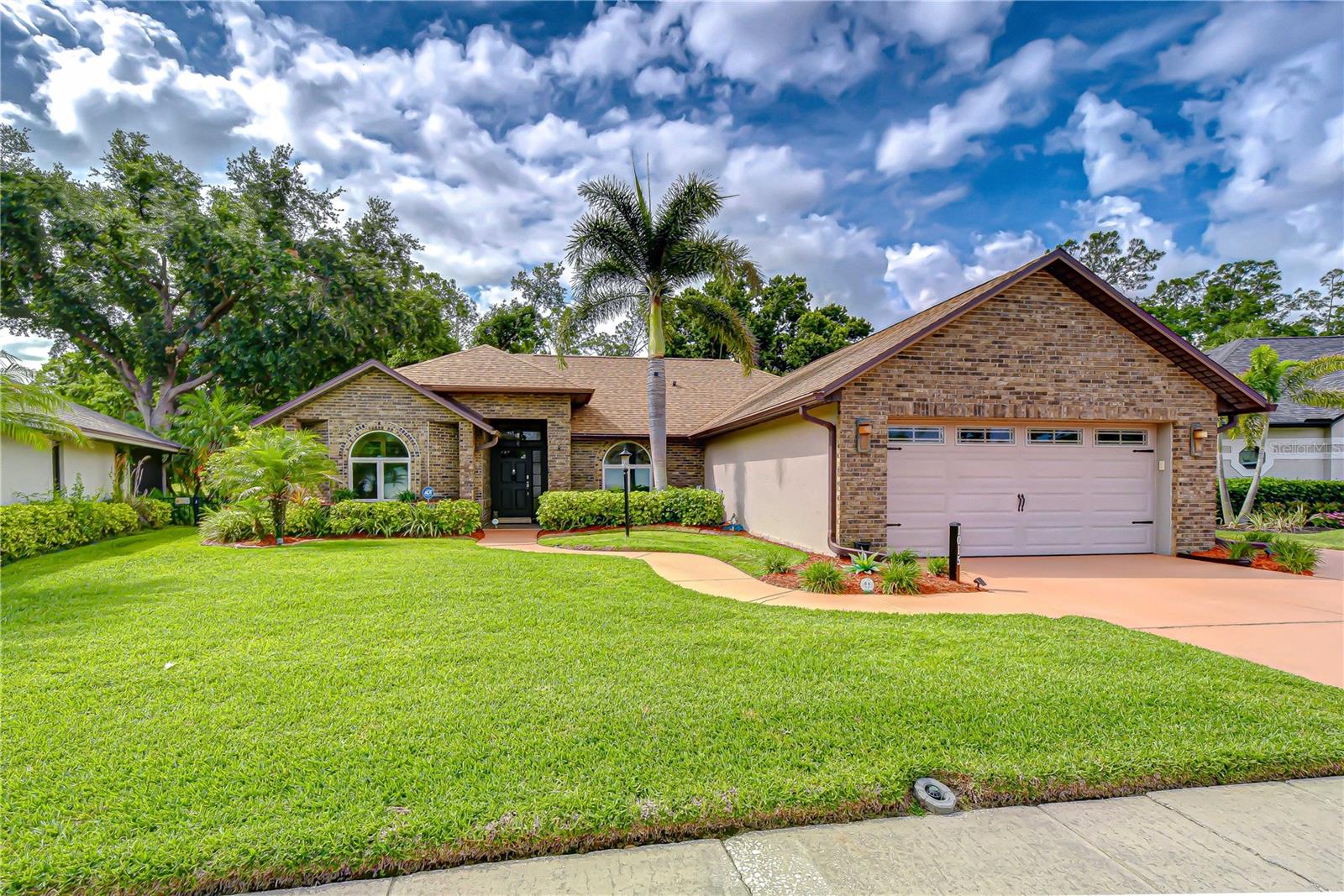 Elegant brick façade with lush landscaping and mature curb appeal