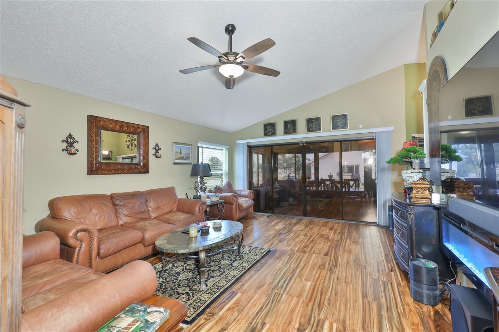 Living Room, Electric Wall Fireplace, Beautiful Acacia Flooring Opens onto the Enclosed Lanai
