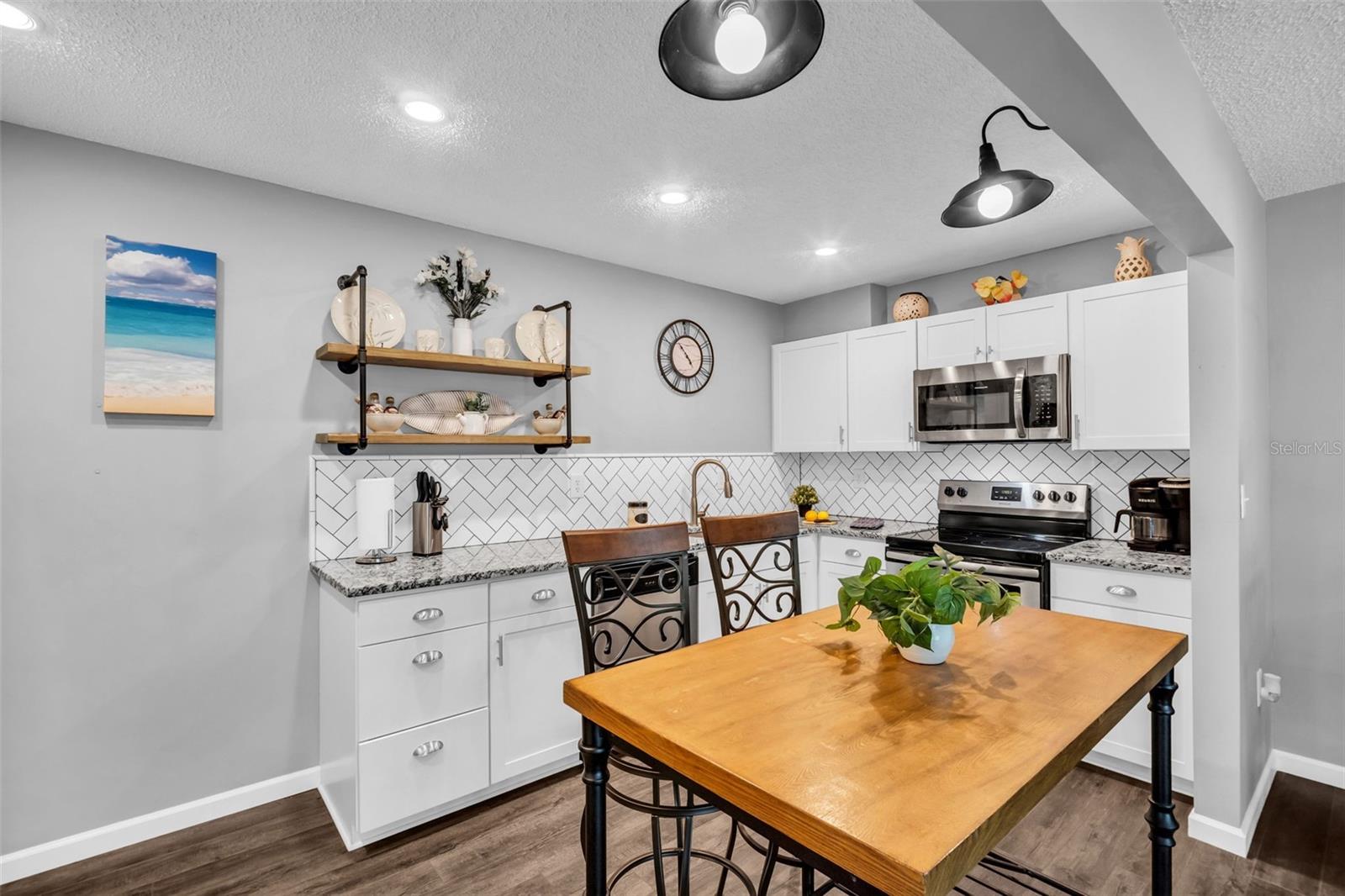 Granite countertops, recessed lighting, and sleek stainless appliances~