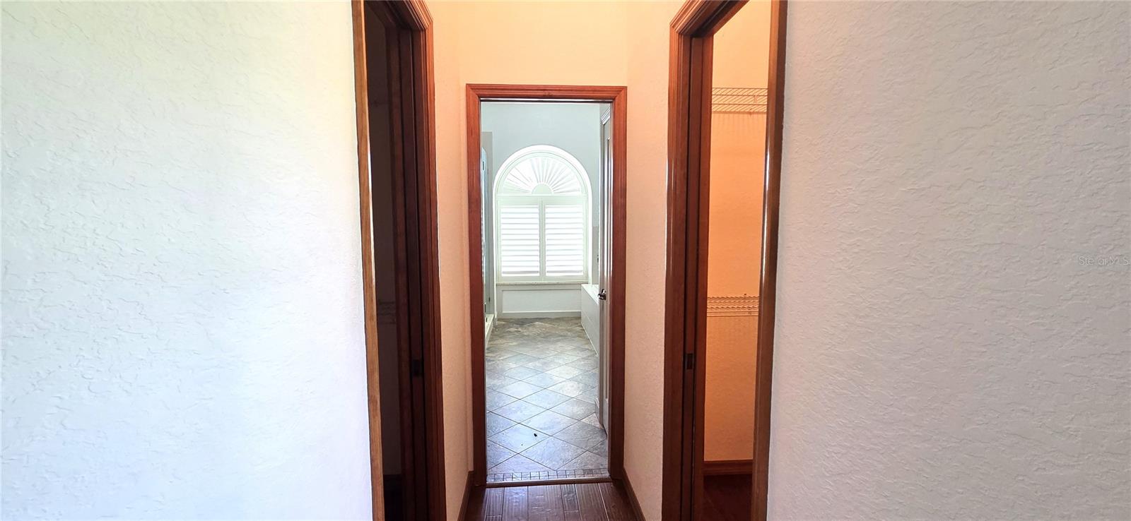 Hallway from Primary Bedroom to En-suite bath w/double closets on each side