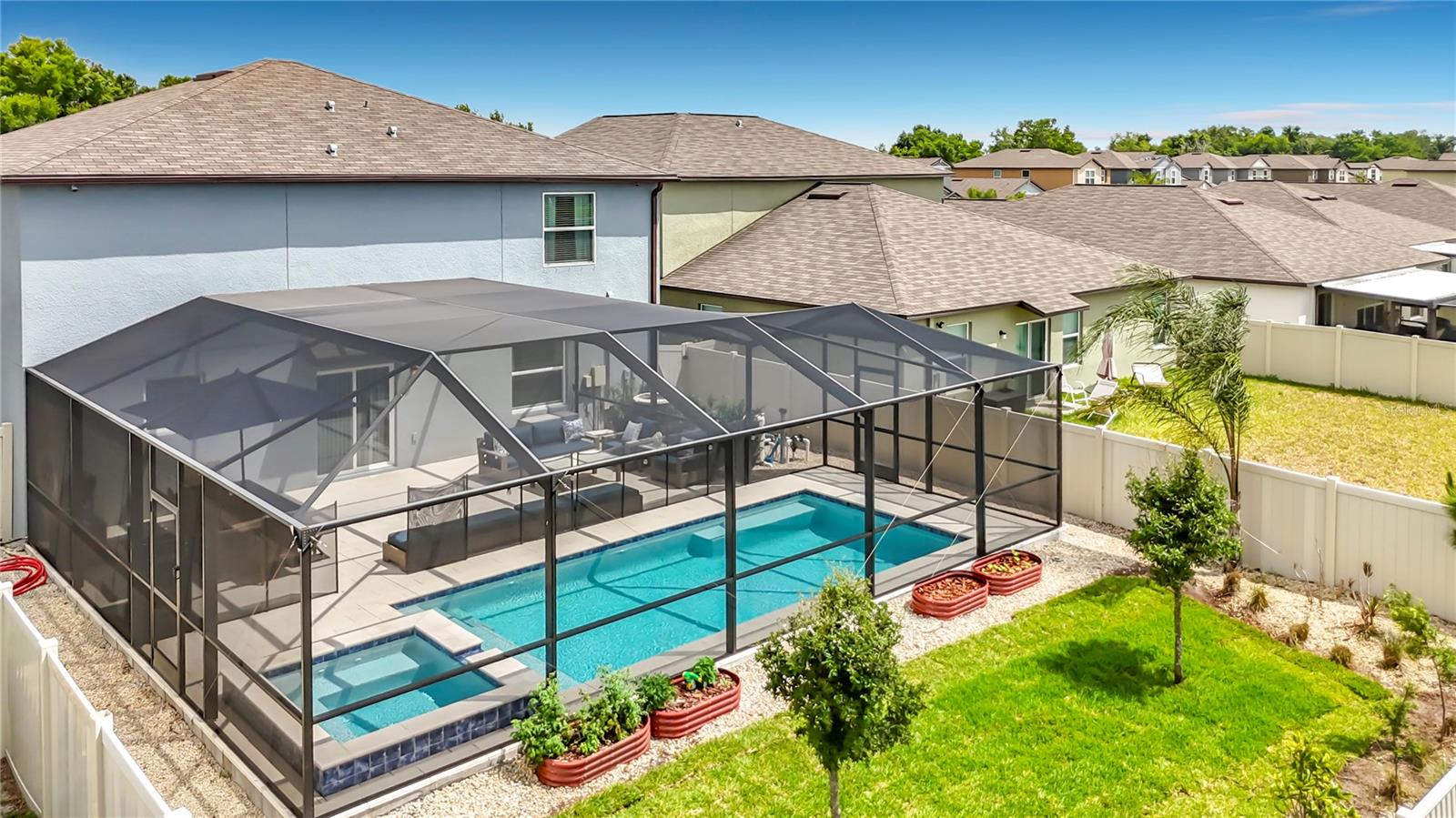 Private backyard retreat featuring an enclosed heated saltwater pool and spa, beautiful pond views, expansive paver decking, and fully fenced yard