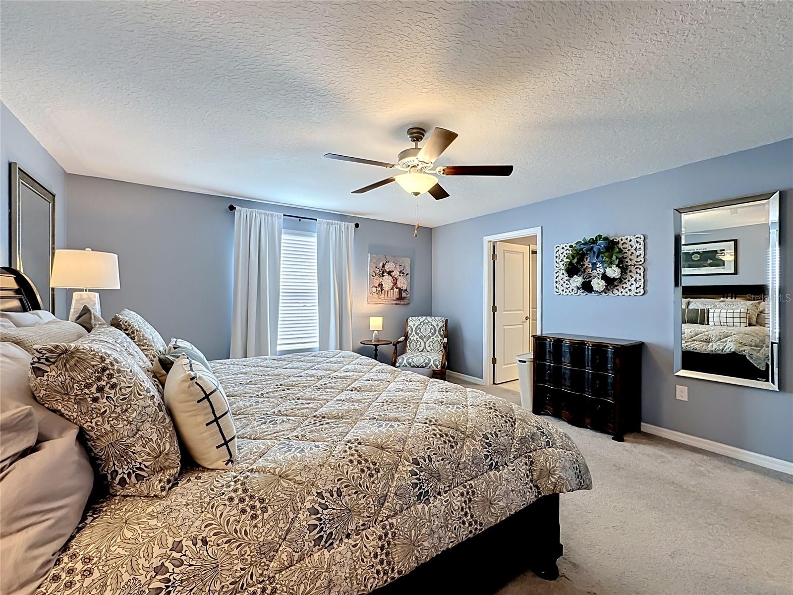 Private primary bedroom retreat with en-suite bathroom and oversized walk-in closet