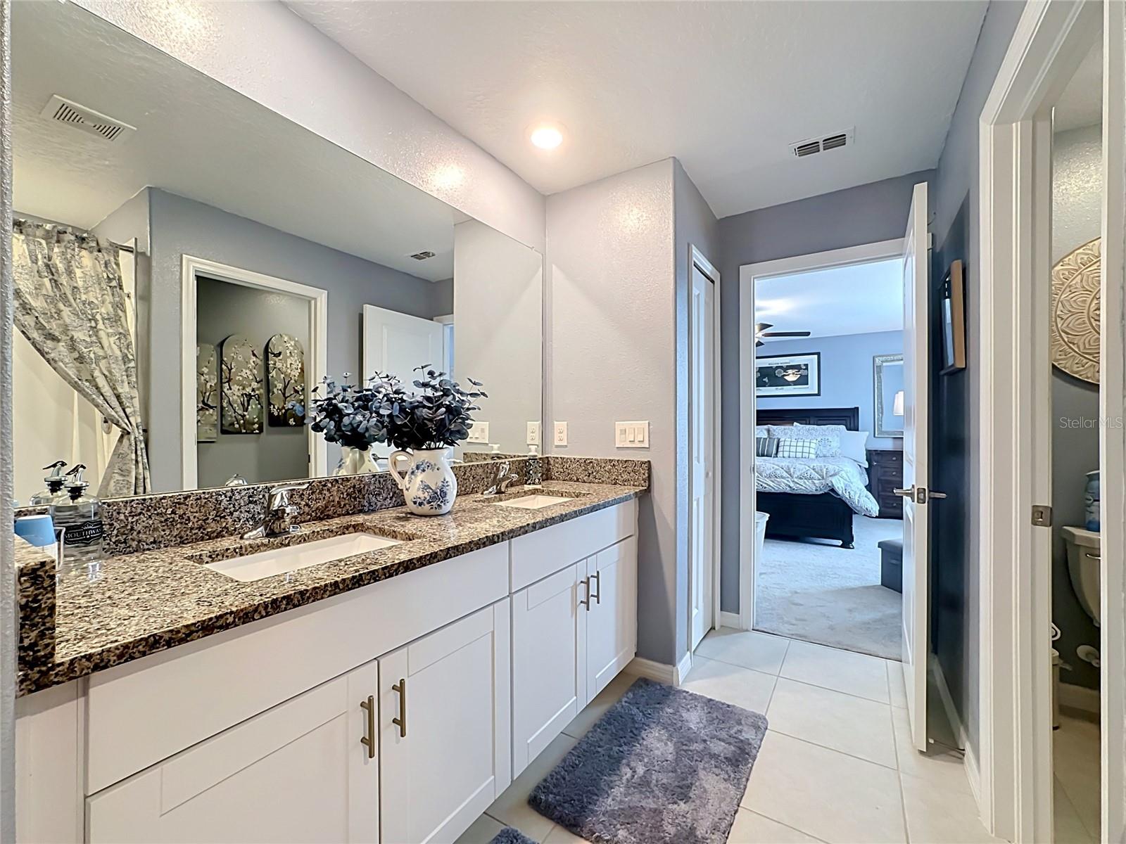 Primary en-suite bathroom with dual sink vanity and step-in shower