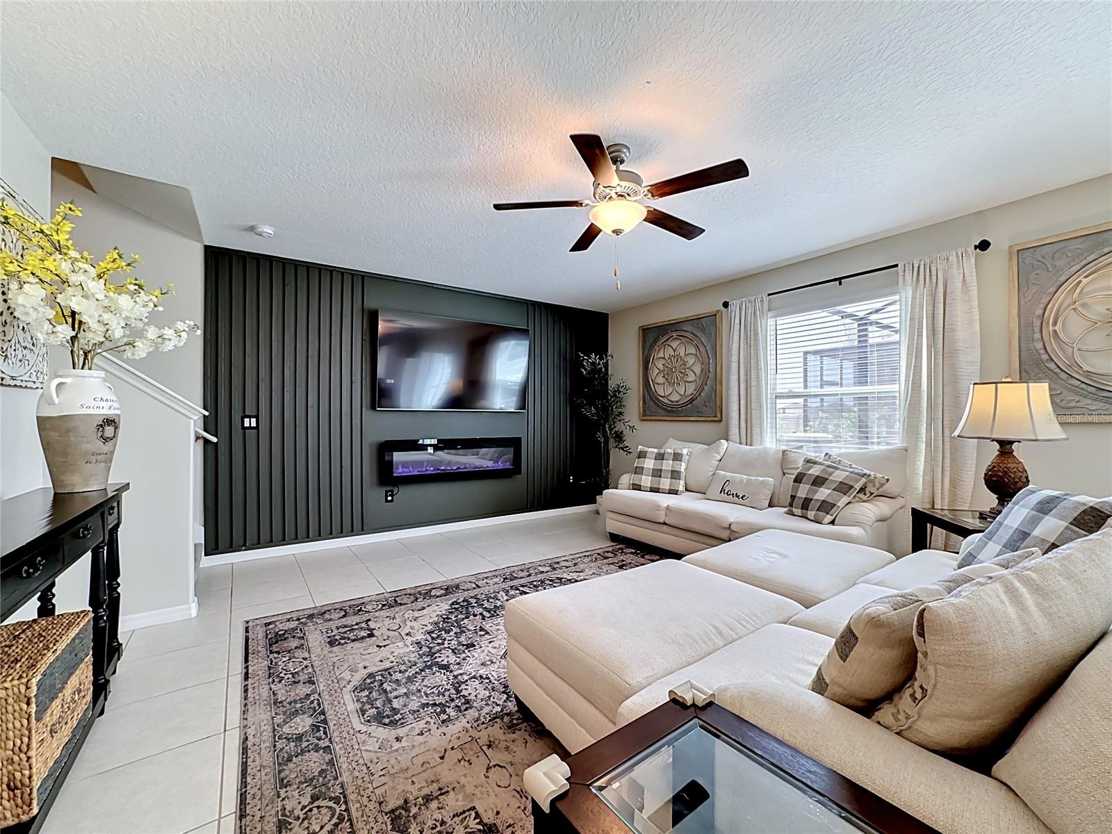 Spacious living room with custom accent wall and electric fireplace