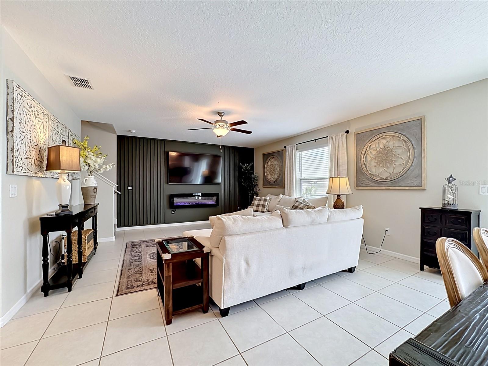 Spacious living room with custom accent wall and electric fireplace