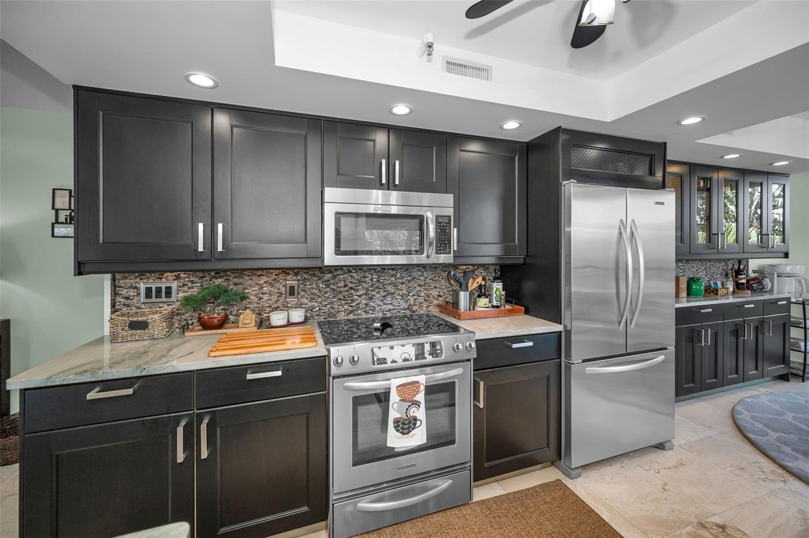 Large Kitchen with charcoal cabinets, stainless steel appliances & Quartz countertops