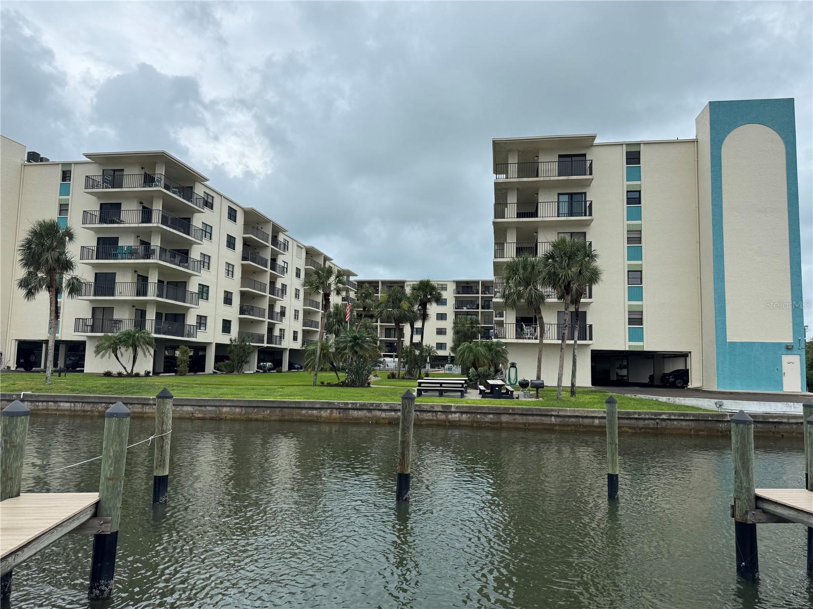 VIEW FROM HOA OWNED DOCK —BAR-B-BQUE NEAR SEAWALL AND POOL AND JACUZZI JUST PAST THE FLAG