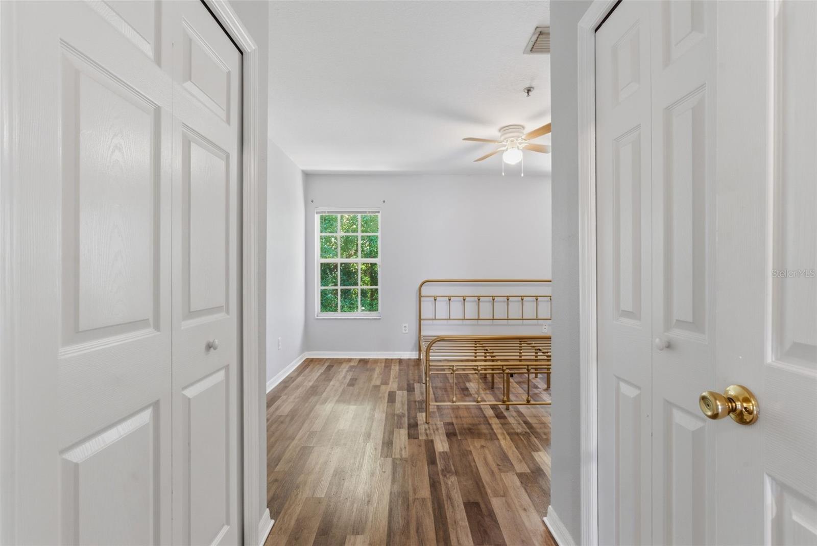 His & hers closets leading into primary bedroom