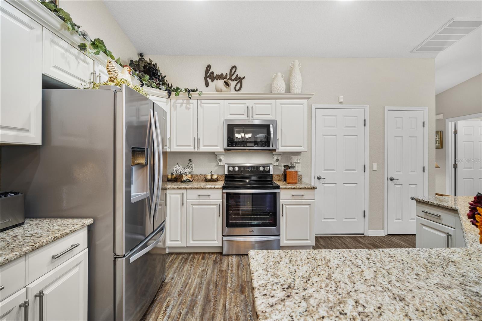 White cabinets with Crown molding and Stainless appliances set off the gleaming granite counters