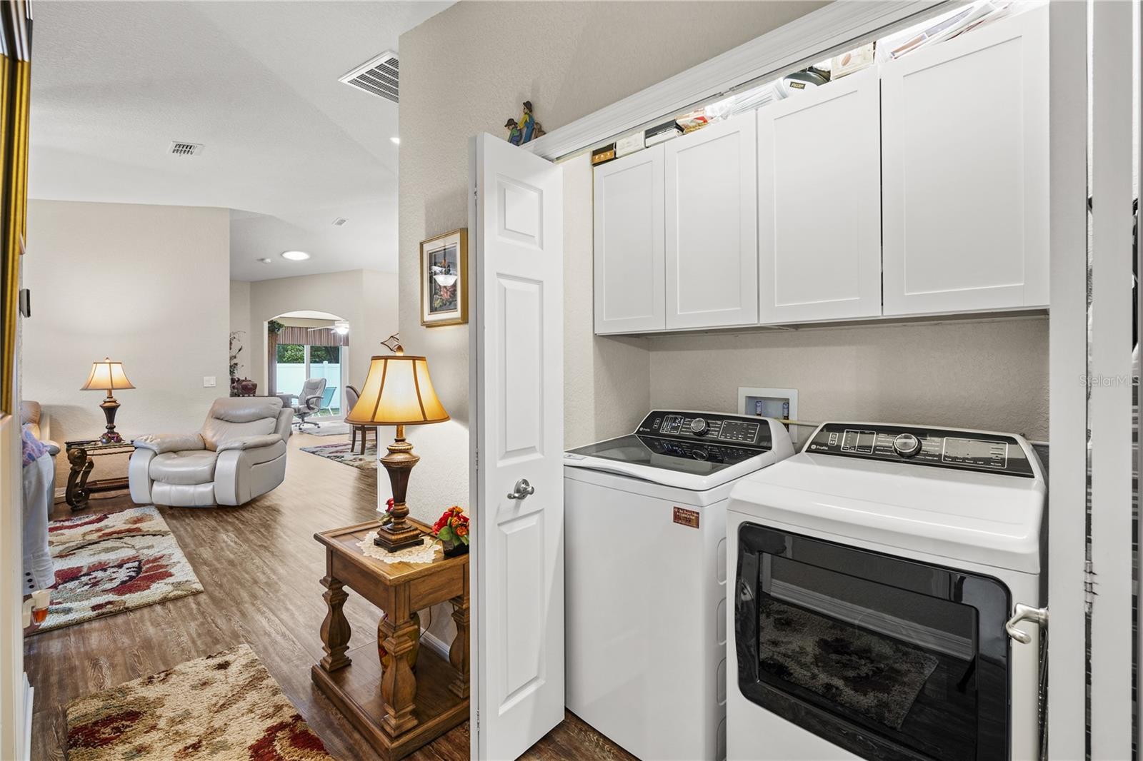 Interior laundry closet with cabinets above