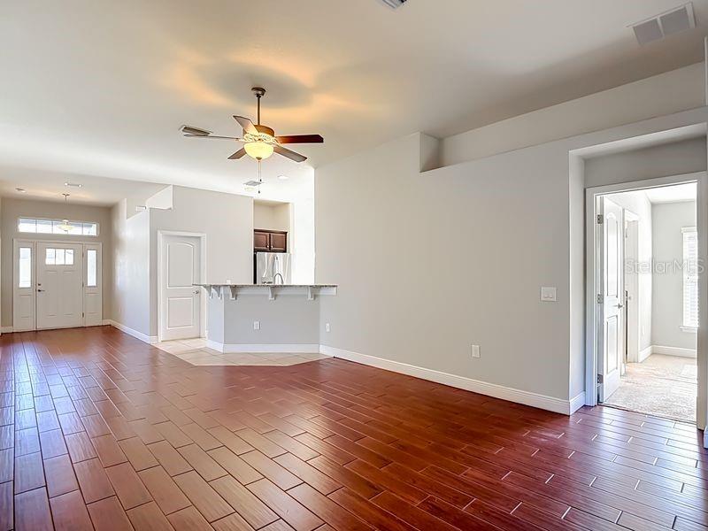 An open-concept living area featuring wood-look flooring and high ceilings that enhance the sense of space and light