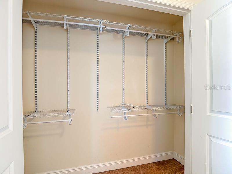 Bedroom 3- a well organized bedroom closet featuring adjustable wire shelving and dual hanging racks, offering flexible storage for clothing and accessories.