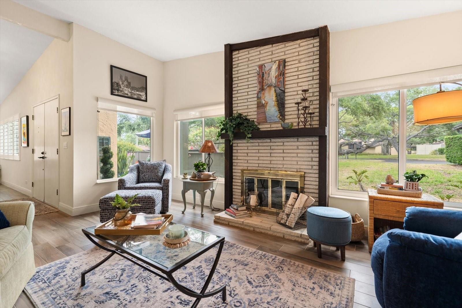 Living room area i light and airy and enhanced by a modern fireplace.
