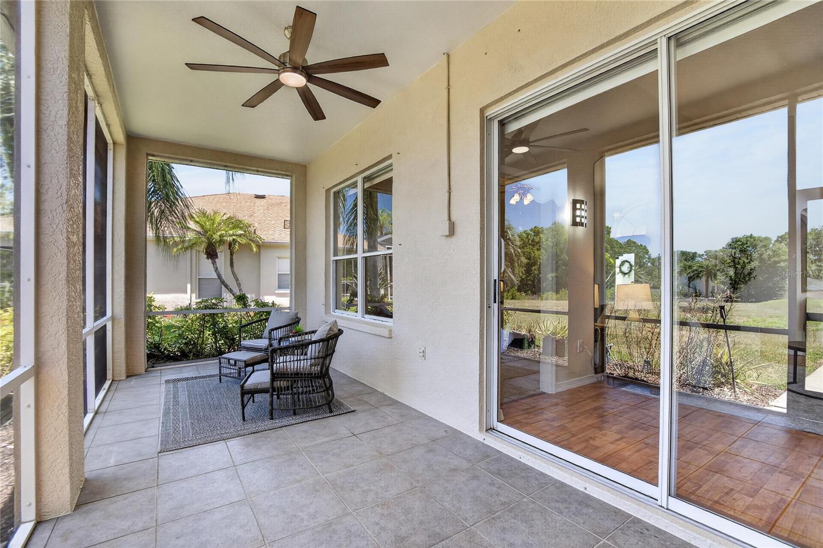 Screened back porch has an overhead fan