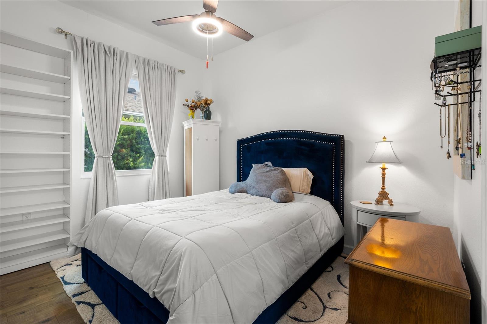 Bedroom 3 features wide-plank luxury vinyl flooring, neutral finishes, built-in shelving, ensuite bathroom and a contemporary ceiling fan.