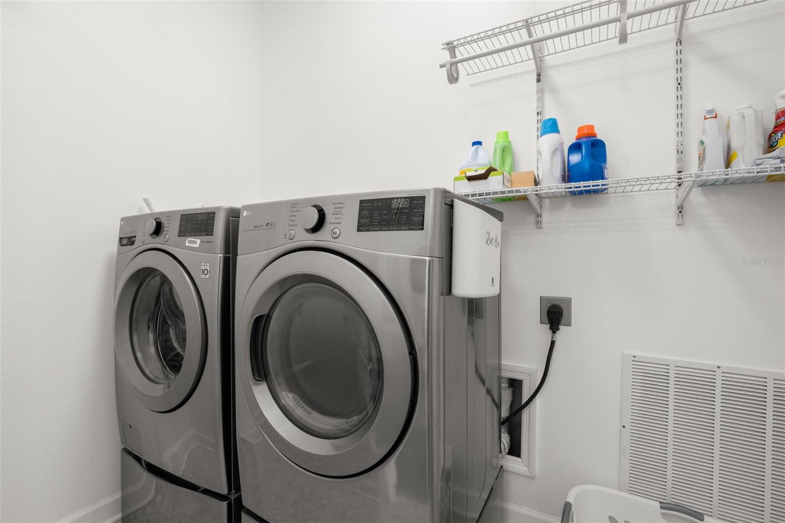 The interior laundry room includes built-in wire shelving for additional organization, side drying racks, and storage space.