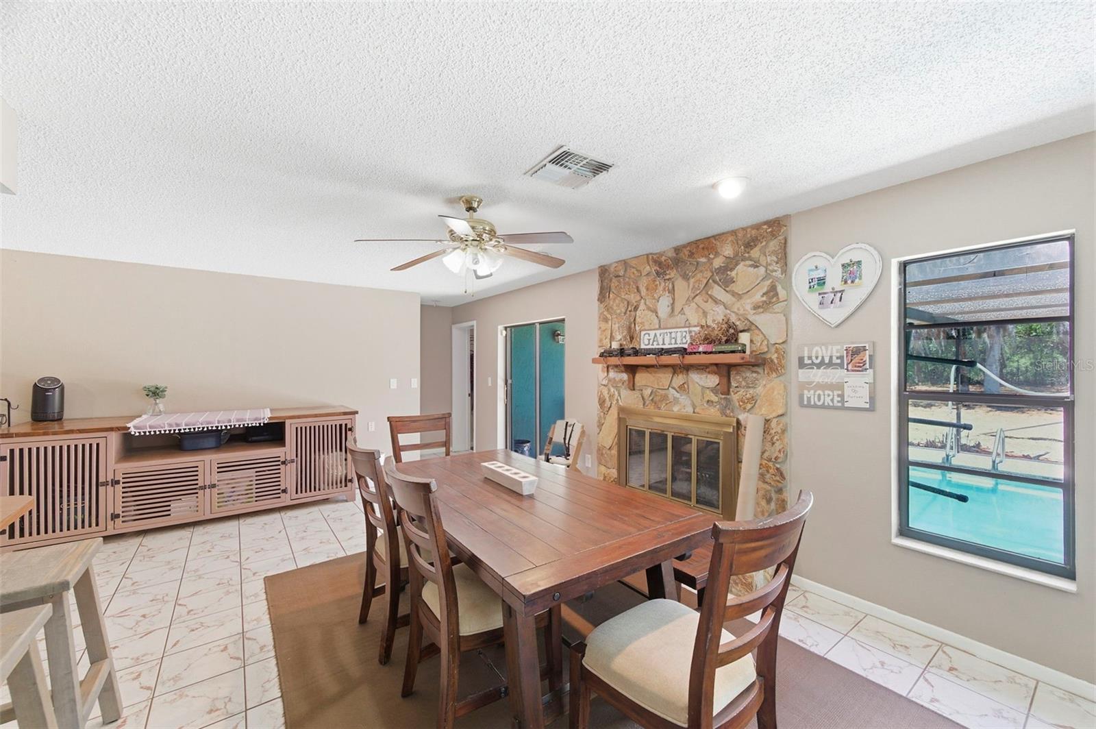 Dining Room with wood-burning fireplace and access to the back patio and lanai.