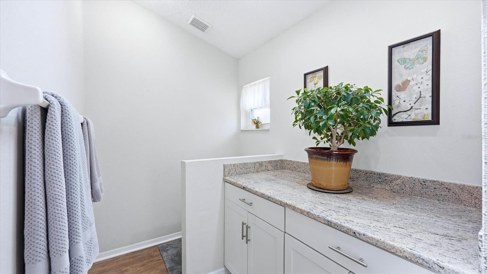 PRIMARY EN-SUITE BATHROOM WITH SKYLIGHT, DUAL CLOSETS WALKIN AND BUILT IN, TALL VANITEIS AND GRANITE COUNTER TOP, WLAK IN SHOWER WITH HERRINGBONE TILE SHOWER FLOOR AND NICHE