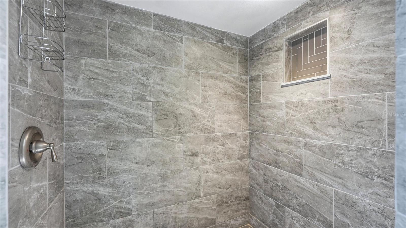 PRIMARY EN-SUITE BATHROOM WITH SKYLIGHT, DUAL CLOSETS WALKIN AND BUILT IN, TALL VANITEIS AND GRANITE COUNTER TOP, WLAK IN SHOWER WITH HERRINGBONE TILE SHOWER FLOOR AND NICHE