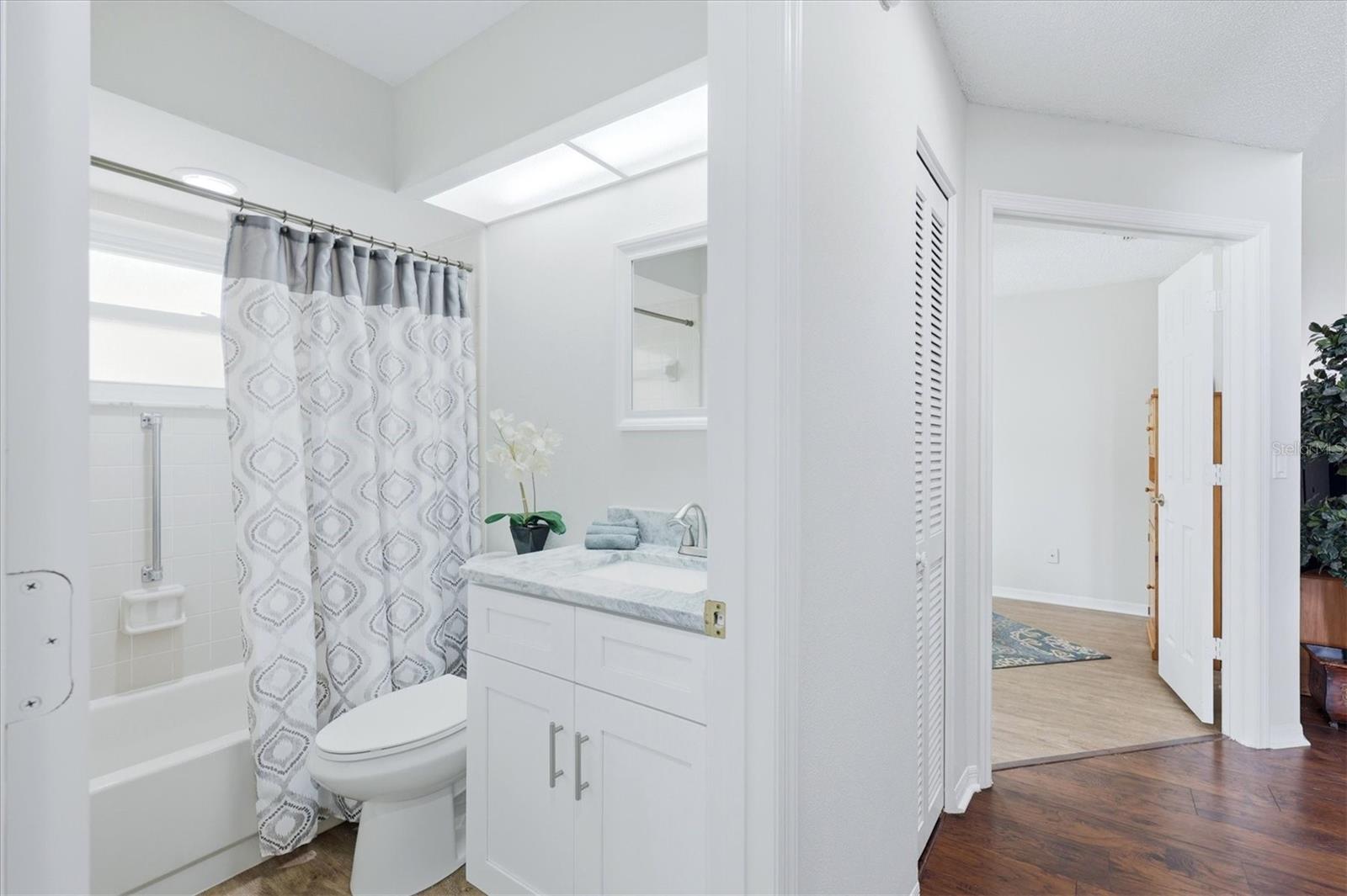 FROM THE SECOND BEDROOM SHOWING THE HALLWAY THE SECOND BATHROOM HAS TALL VANITY AND GRANITE COUNTERTOP
