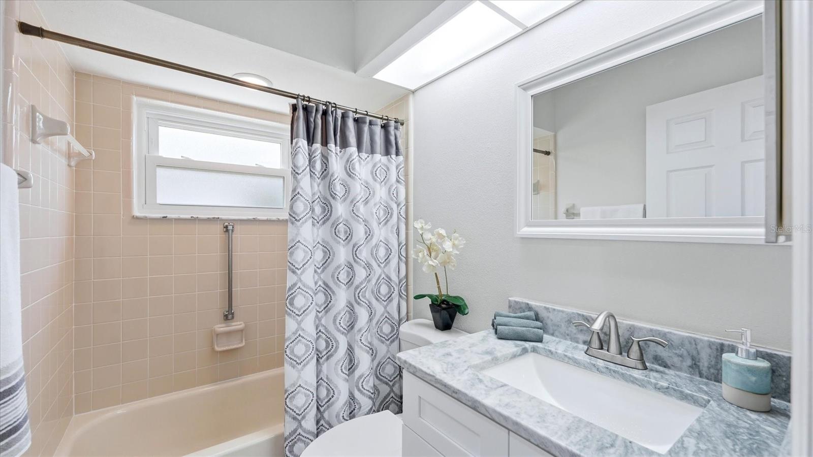 THE SECOND BATHROOM HAS TALL VANITY AND GRANITE COUNTERTOP WITH TUB AND SHOWER COMBINATION