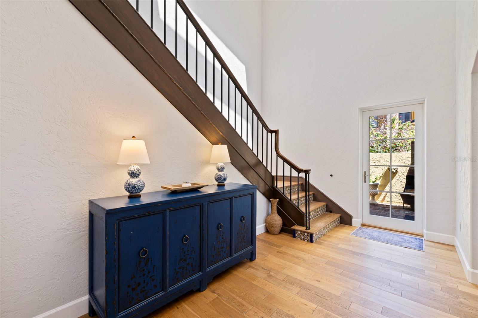 Grand stairs to the bedrooms. The door goes out to the outdoor dining are and the executive office.
