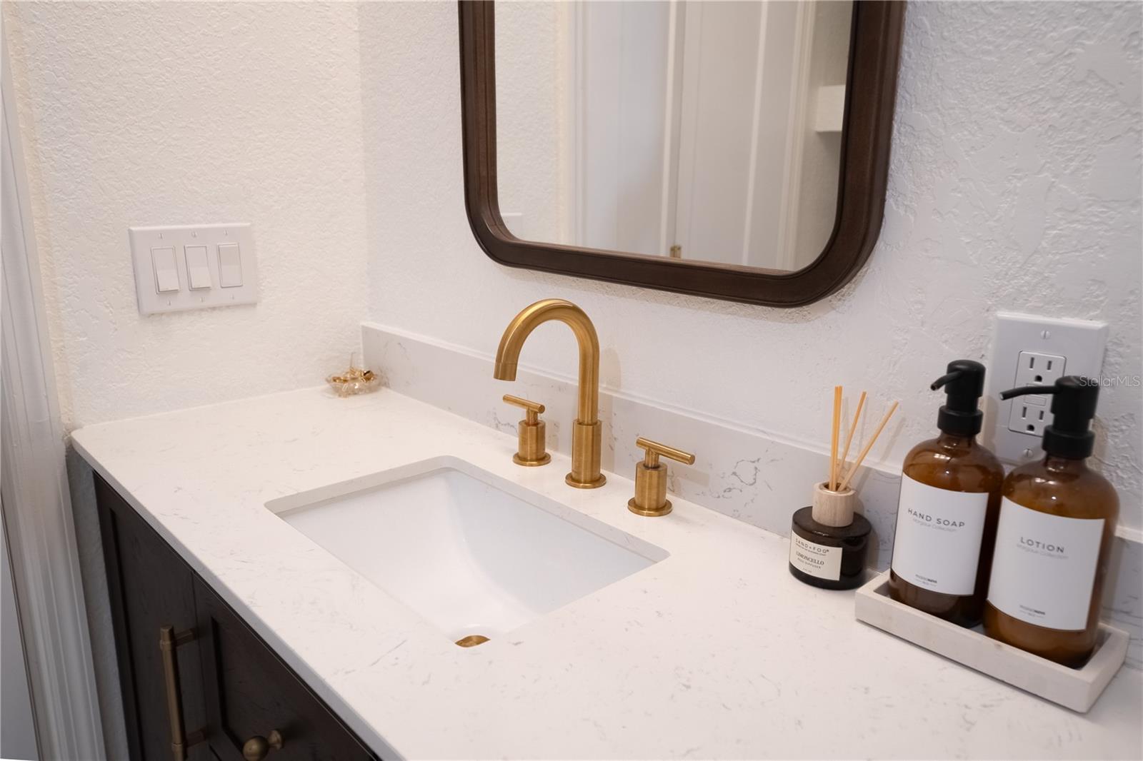 Gold hardware and stone countertop in primary bathroom