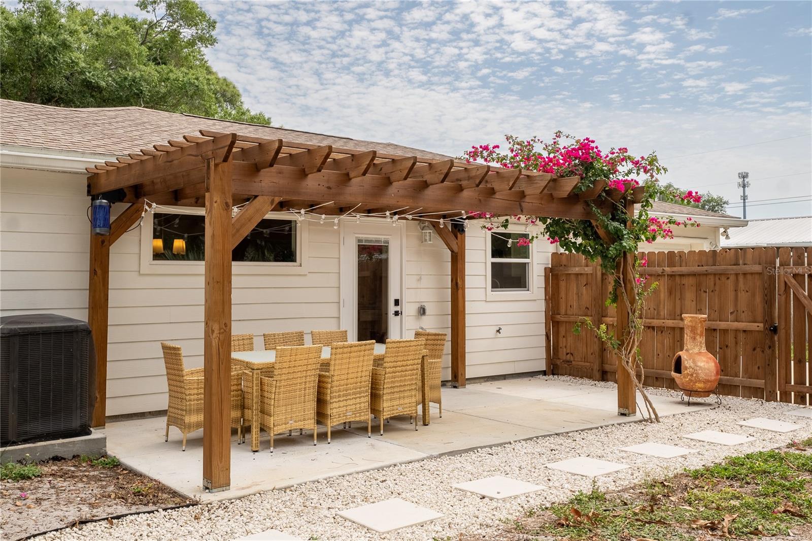 Patio & pergola in backyard with gorgeous blooming bougainvillea providing additional shade