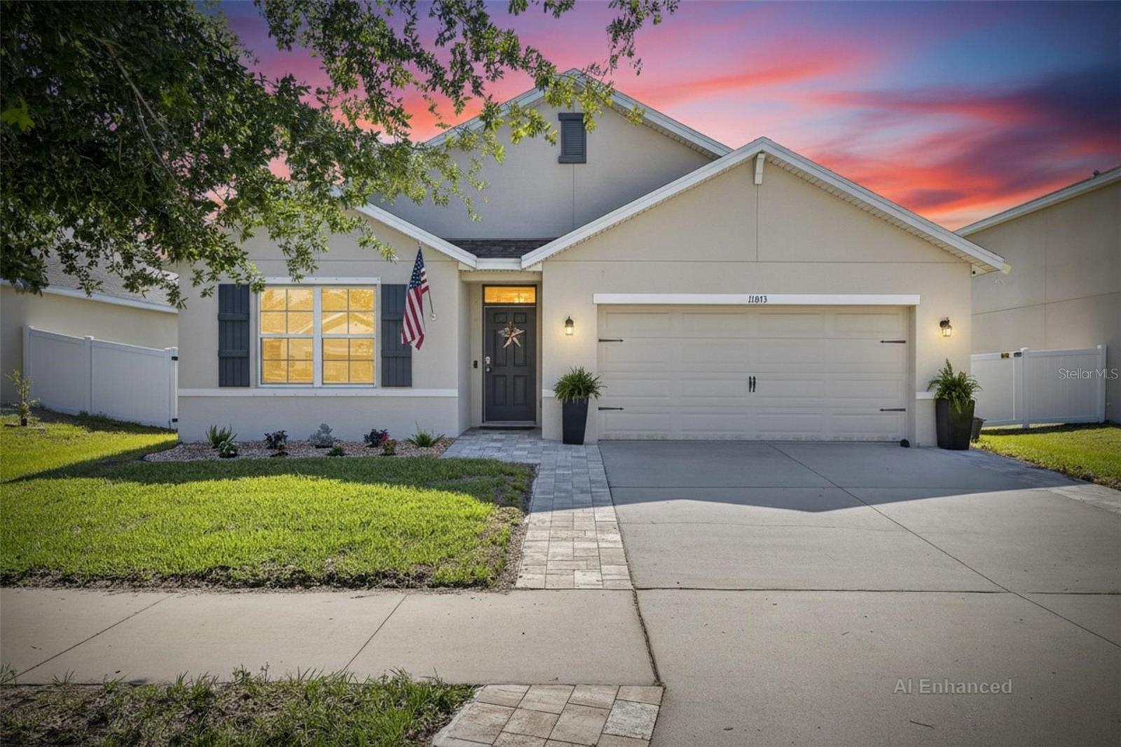 Enhanced curb appeal with extended brick paver driveway, upgraded landscaping, and inviting covered entry.