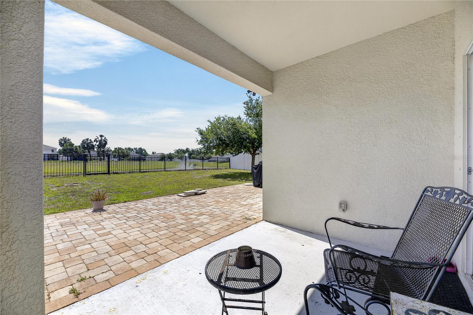 Covered lanai with extend pavers and pond views