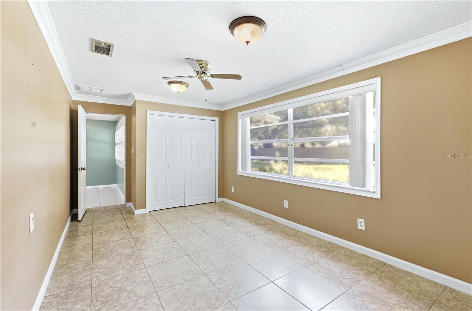 Primary bedroom offers beautiful flooring, a ceiling fan and en-suite bathroom