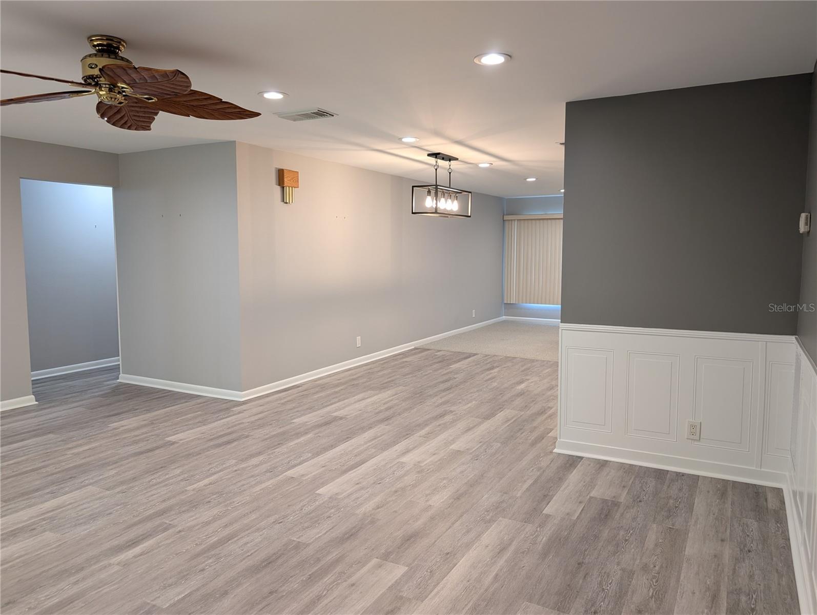 View of open floor plan...living room thru dining room into Florida room.  Hallway to both bedrooms and baths on left.
