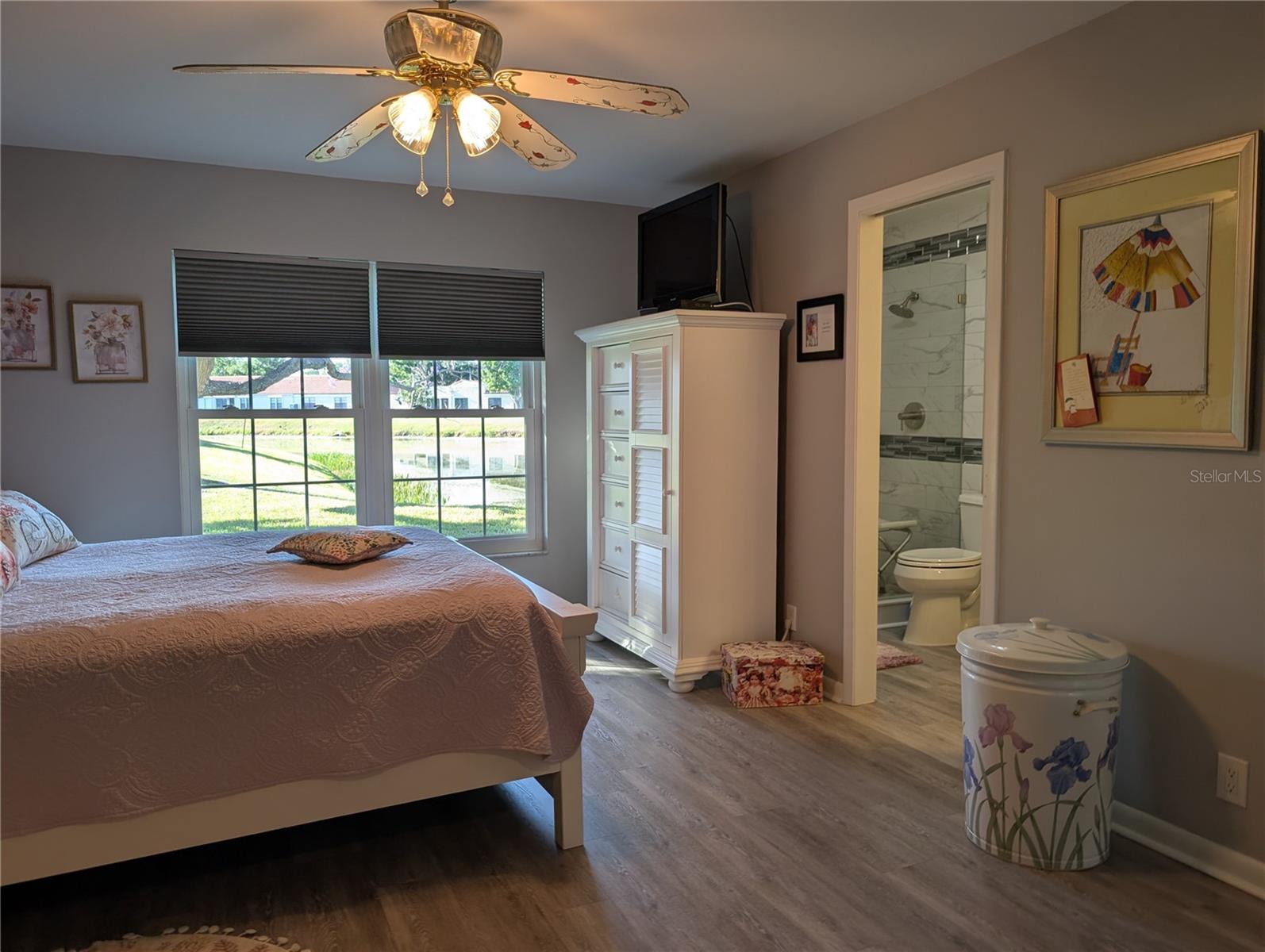 Spacious Master bedroom shares the spectular water view. Other features include ceiling fan w/light, newer luxury vinyl flooring (2023) and a private ensuite bath.