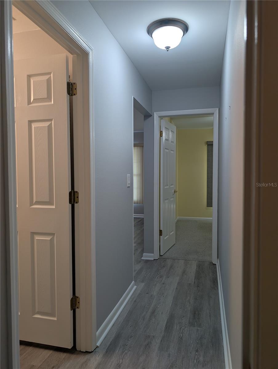 Hallway view from Primary bedroom to Guest bedroom.  Guest bathroom on left, entry to living area just before guest bedroom.