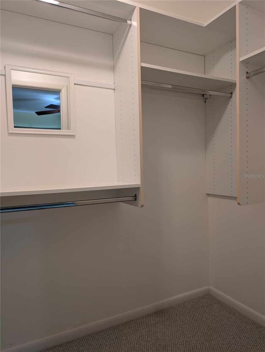 Well organized walk in closet provides great storage.