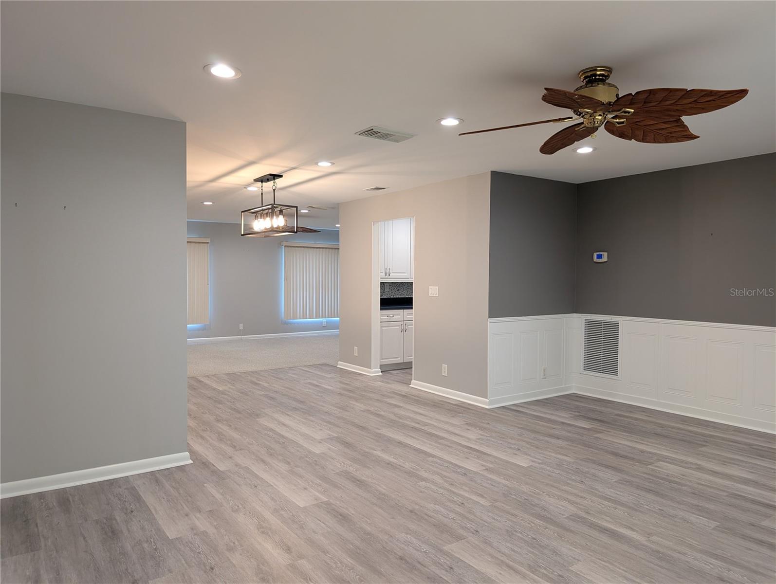 Open floor plan view of living room into dining room, kitchen and Florida room.