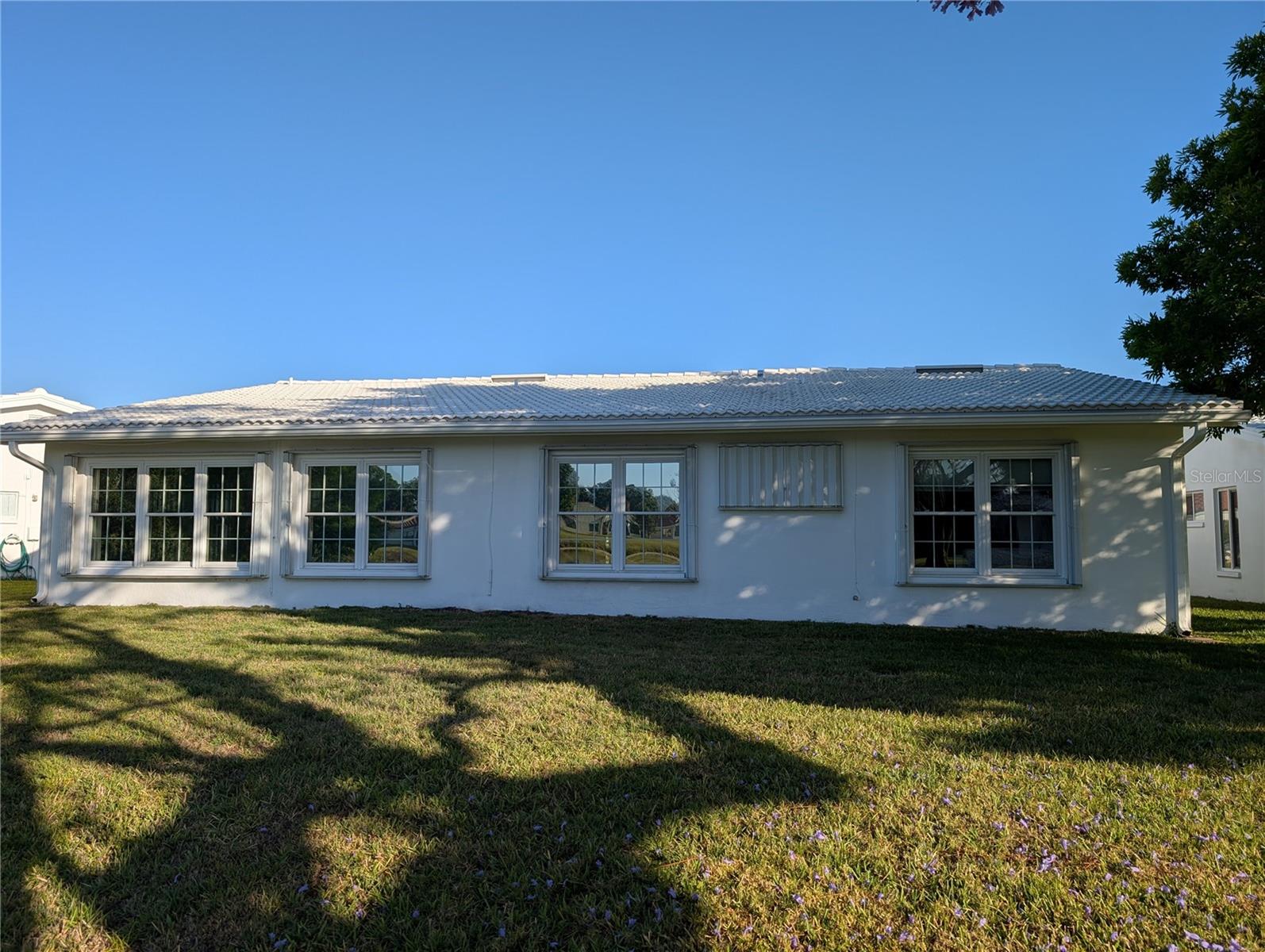 Exterior view of back of the home.  Accordion storm shutters to protect during storm season. Updated tile roof 2020.