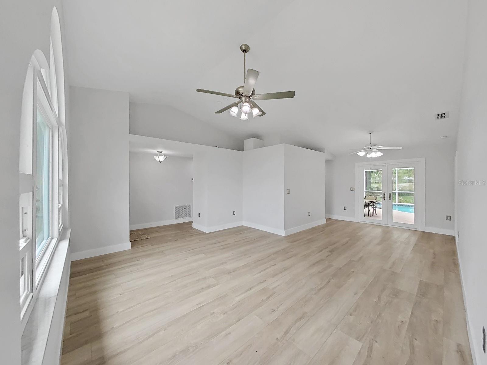 Living room has double doors to the patio and pool.