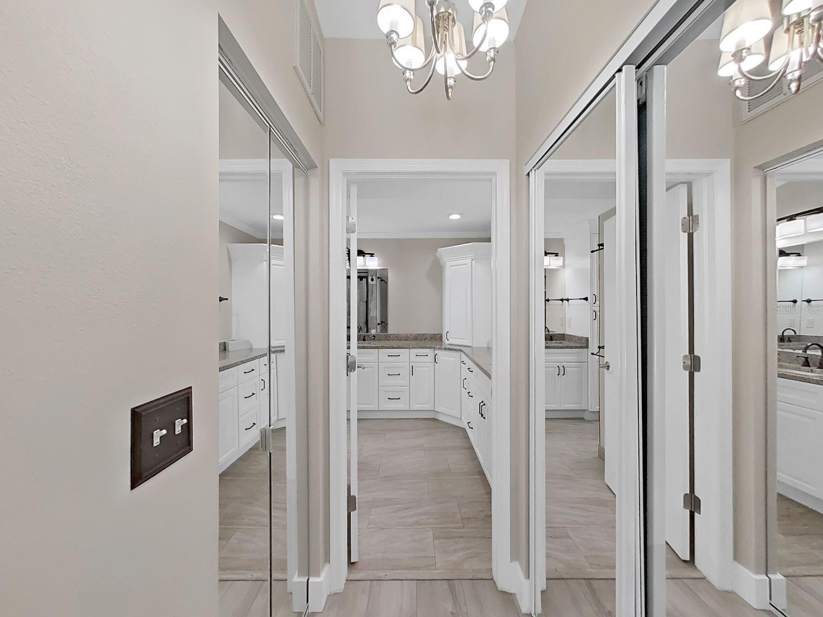 Mirrored closet doors, peaking into the primary bath, ensuite style.