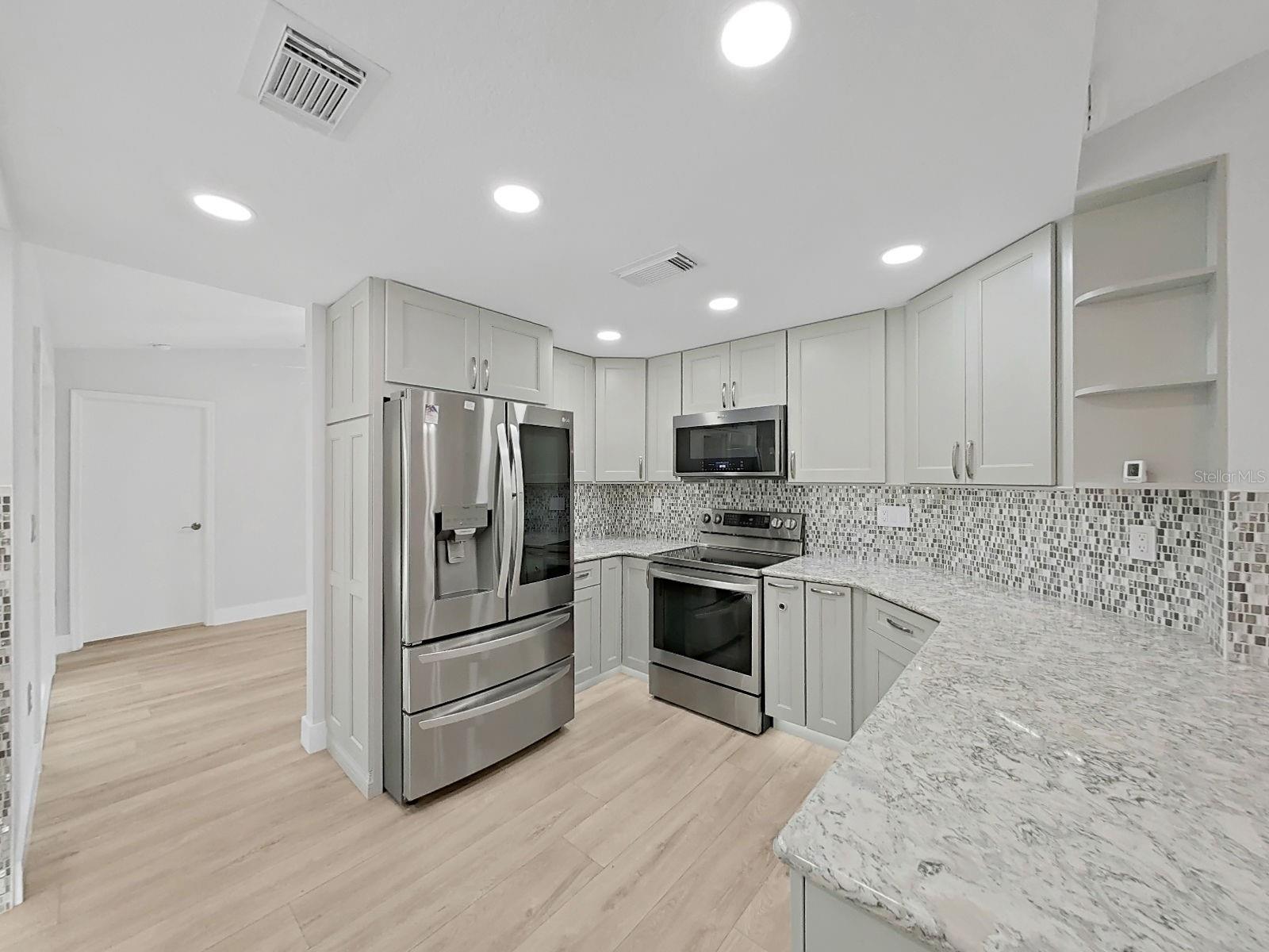 Fall in love with this cooks kitchen. Light gray cabinets, granite tops, all top of the line stainless steel appliances.