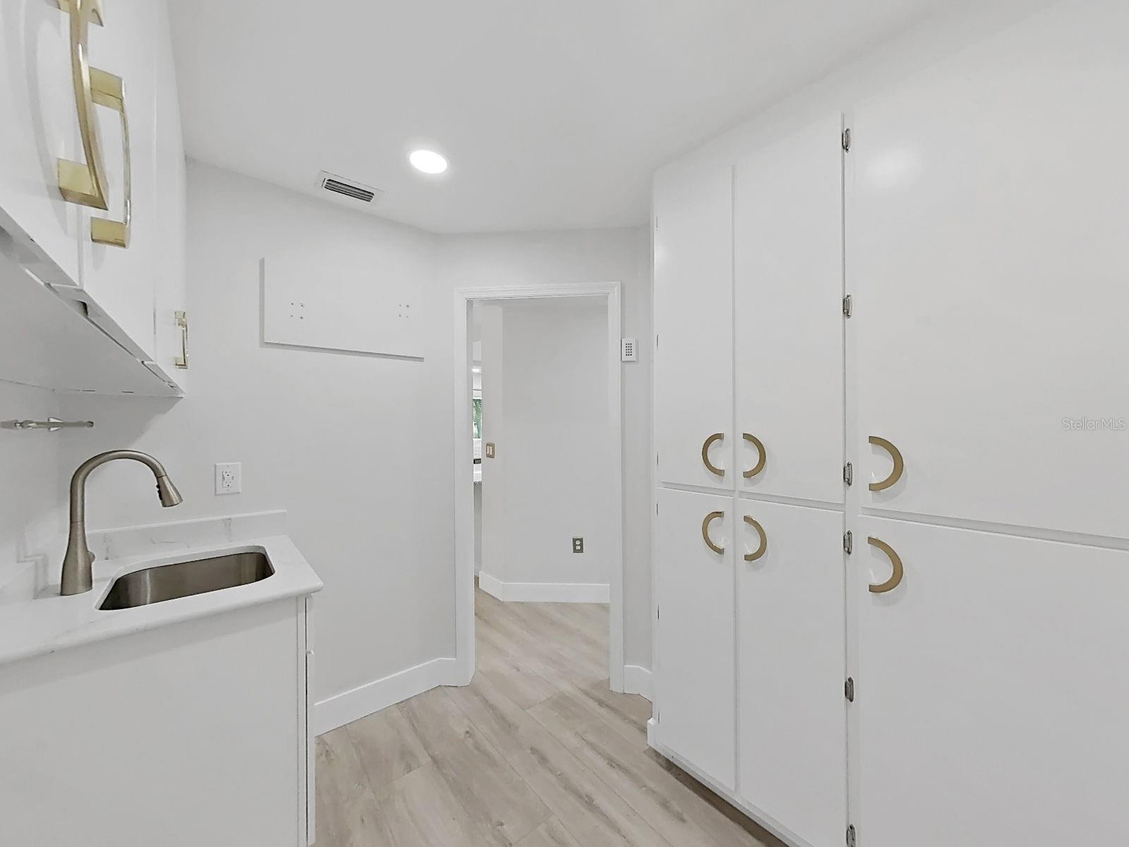Laundry room with built in utility sink, lots of storage. Plus a door into the garage.