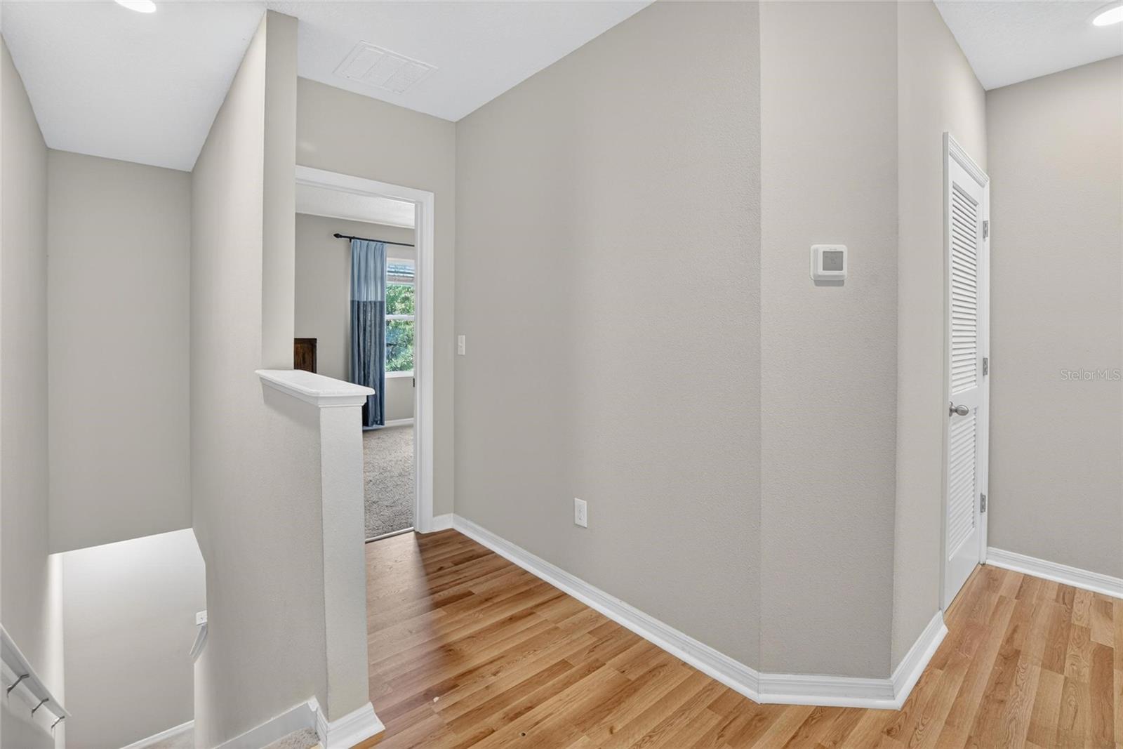 WOOD FLOORS IN HALLWAY LEADS TO PRIMARY BEDROOM