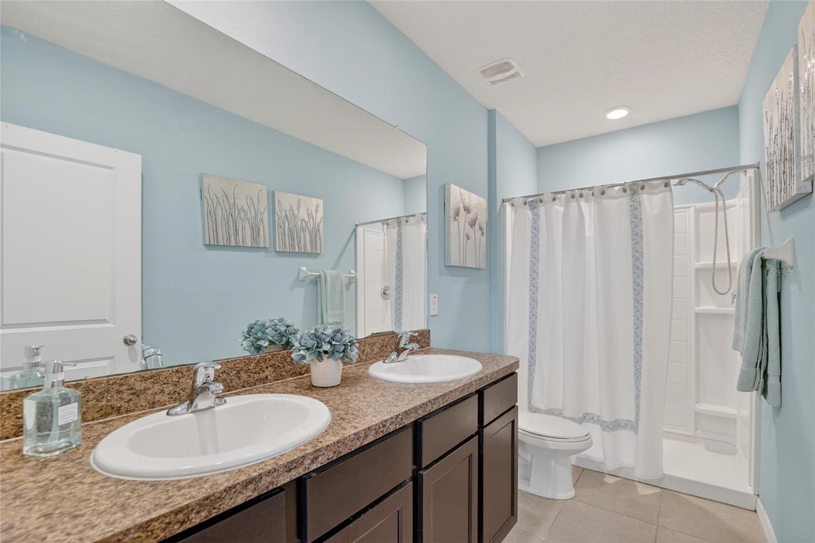 EN SUIT BATHROOM HAS A LARGE VANITY WITH TWO SINKS