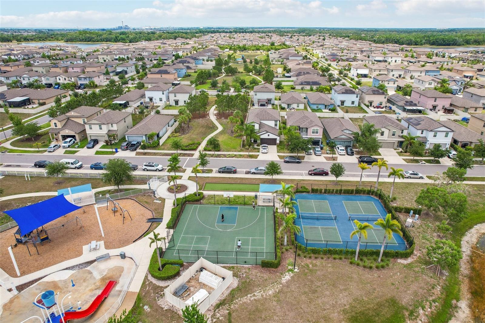 PLENTY TO KEEP THE FAMILY ENTERTAINED!! AMENITY AERIAL OVERVIEW OF TENNIS COURTS, BASKETBALL, PLAYGROUND AND WATER PARK