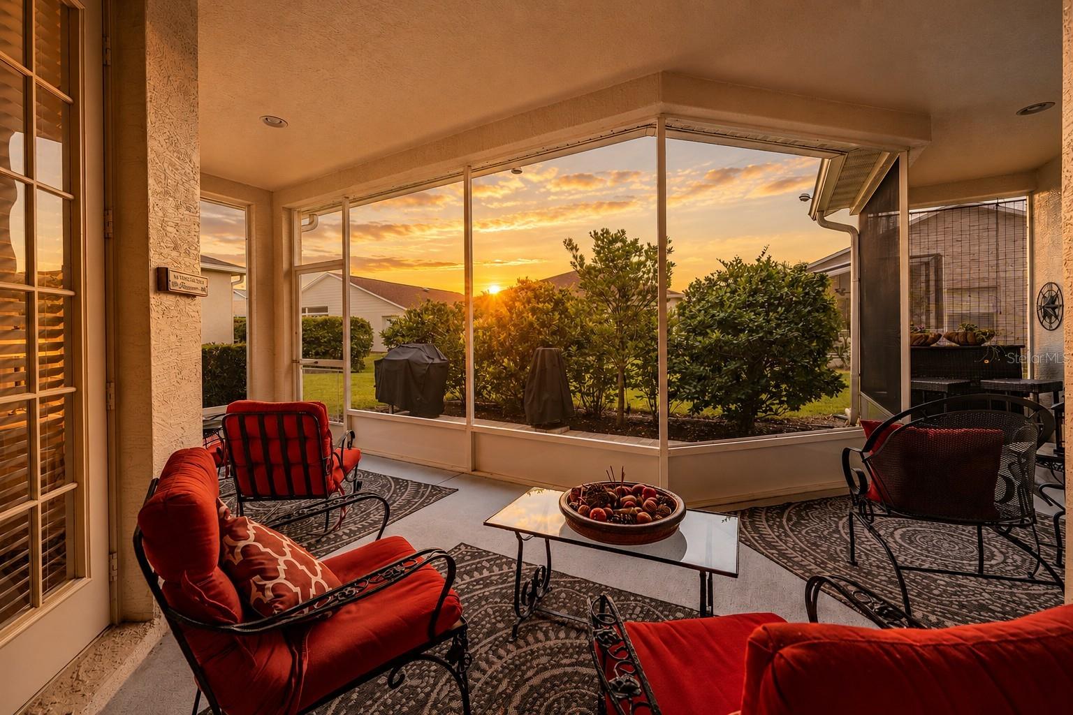 Screened in lanai with a privacy hedge during sunset