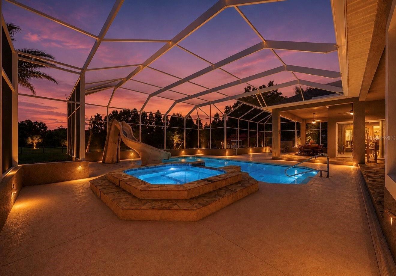 Custom pool and spa with slide nighttime