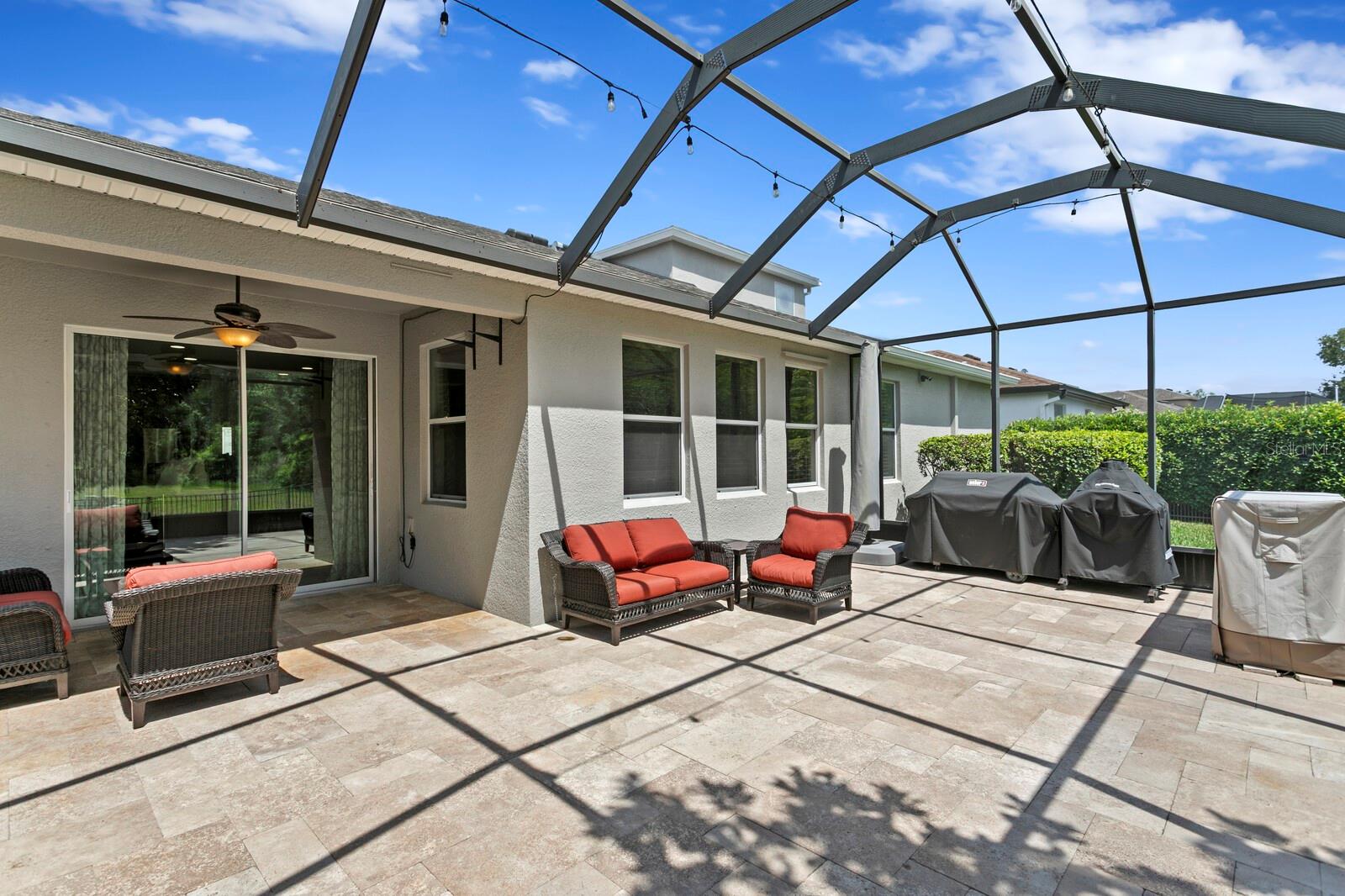 Extended birdcage lanai with travertine pavers