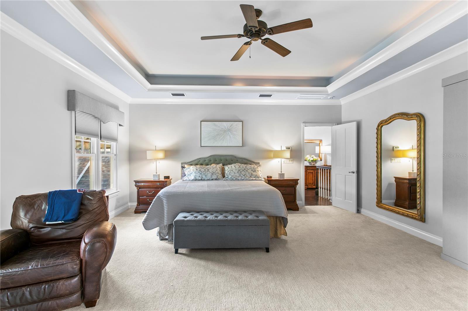 The spacious primary bedroom features an elegant tray ceiling and a relaxing atmosphere.